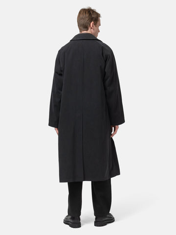 Rear shot of the Model standing in studio wearing the A.PRESSE Maxi Length Washed Silk Balmacaan Coat in Black 