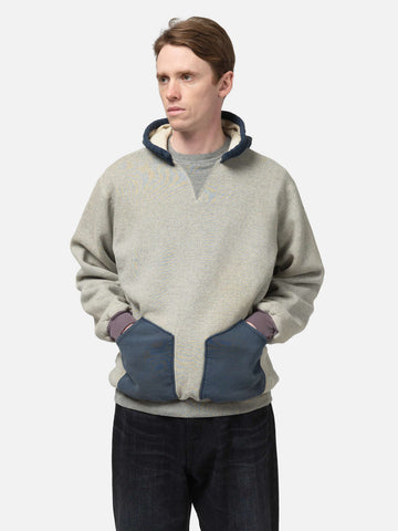 Hlaf body shot of the Model standing in studio wearing the A.PRESSE Vintage Attached Hood Sweat Parka in Oatmeal