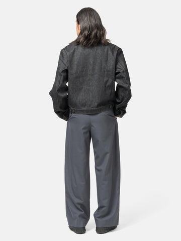 Rear view of the model wearing LEMAIRE Pleated Tailored Pants Carbon