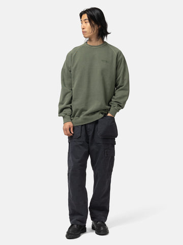 Full body shot of the model wearing the Neighborhood Pigment Dyed Sweat Shirt LS Olive Drab