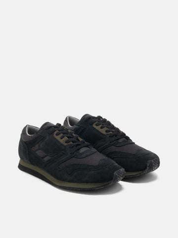 Three quarter view of the Reproduction of Found British Military Trainer in Black premium suede and nylon photographed in studio.