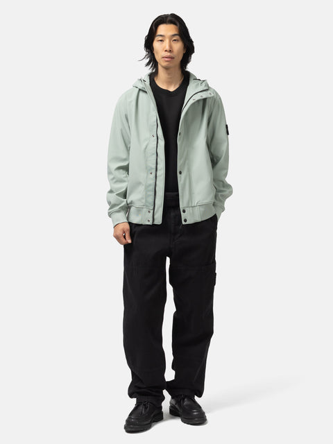 Full body shot of the model wearing the Stone Island Light Soft Shell-R_E.Dye® Technology Hooded Jacket Sage