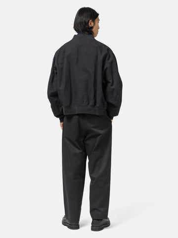 Rear view of the model standing in studio of the cotton canvas MA-1 Blouson from URU.