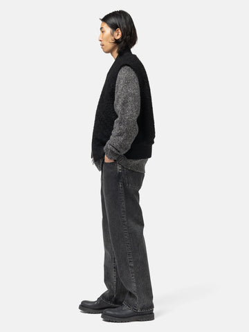 Side shot of the model standing in studio wearing the cotton denim 5 pocket wide pants in black from URU