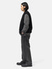Side shot of the model standing in studio wearing the cotton denim 5 pocket wide pants in black from URU