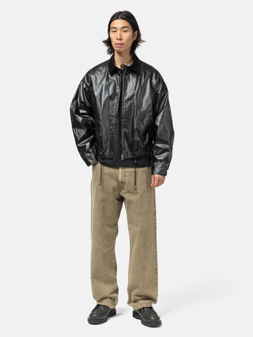 Model standing in studio wearing the cotton denim 5 pocket wide pants in brown from URU