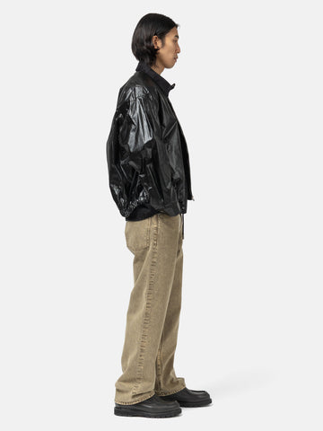 Side shot of the Model standing in studio wearing the cotton denim 5 pocket wide pants in brown from URU