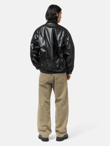 Rear view of the model standing in studio wearing the cotton poplin zip-up Blouson from URU.