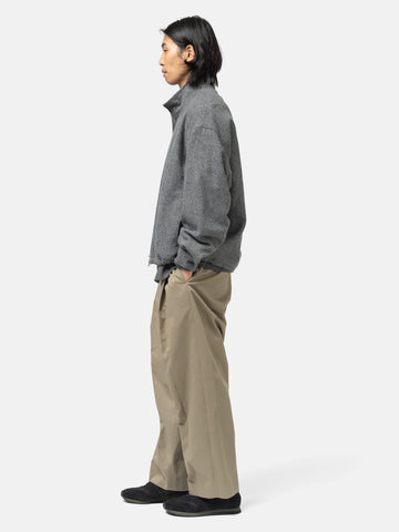 Side shot of the model standing in studio wearing the URU Organic Cotton Chino 1 Tuck Pants