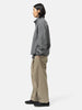 Side shot of the model standing in studio wearing the URU Organic Cotton Chino 1 Tuck Pants
