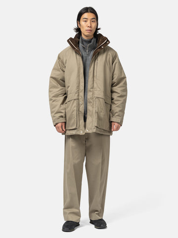 Model standing in studio wearing the organic cotton chino half coat from URU.