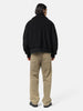 Rear view of the model standing in studio wearing the wool boa zip-up blouson from URU.