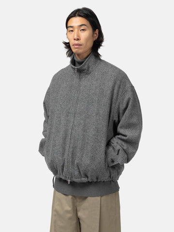 Close-up shot of the Model in studio wearing the wool light tweed zip-up blouson from URU.