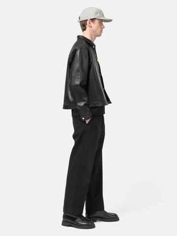 side view of the Model standing in studio wearing the UNLIKELY Skater's Work Pants in Black