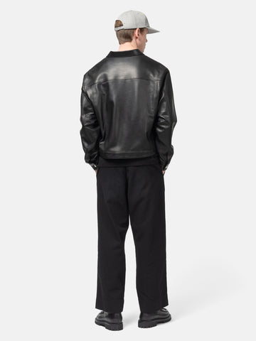 Rear view of the Model standing in studio wearing the UNLIKELY Skater's Work Pants in Black