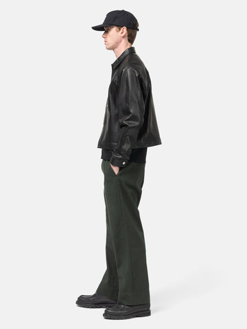 Side view of the model standing in the studio wearing the  ULIKELY Skater's Work Pants in Green