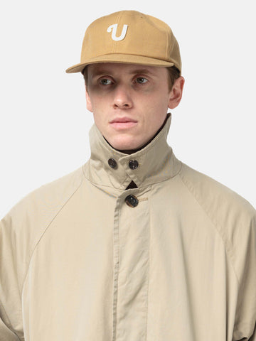 Shot in studio of the UNLIKELY Team Cap in Beige worn by the model