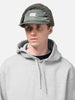 Model is wearing WTAPS AVT Cap Nylon. Satin in Cordura Olive Drab with ear flap attached