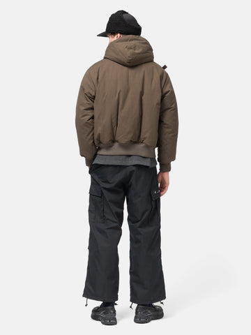 Rear view of the Model standing in studio wearing the WTAPS MILT9601 Trousers NYCO in Weather Black