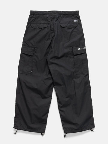 Falt shot of the back of the Model standing in studio wearing the WTAPS MILT9601 Trousers NYCO in Weather Black