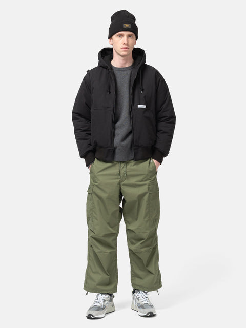 Model standing in studio wearing the WTAPS MILT9601  Trousers NYCO Weather in Olive Drab